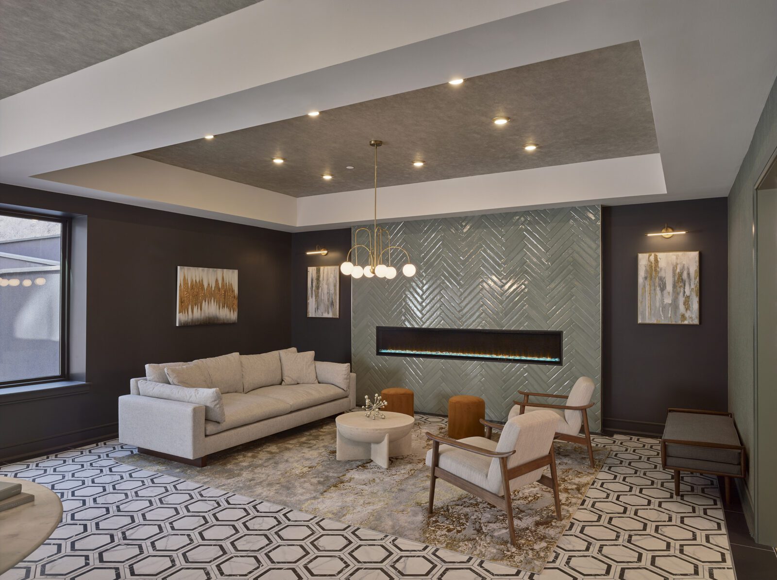 photo of the lounge in the Aster's lobby. the room has a variety of seating options, a fireplace in the wall, and gold accents including a rug, light fixtures, and abstract wall art