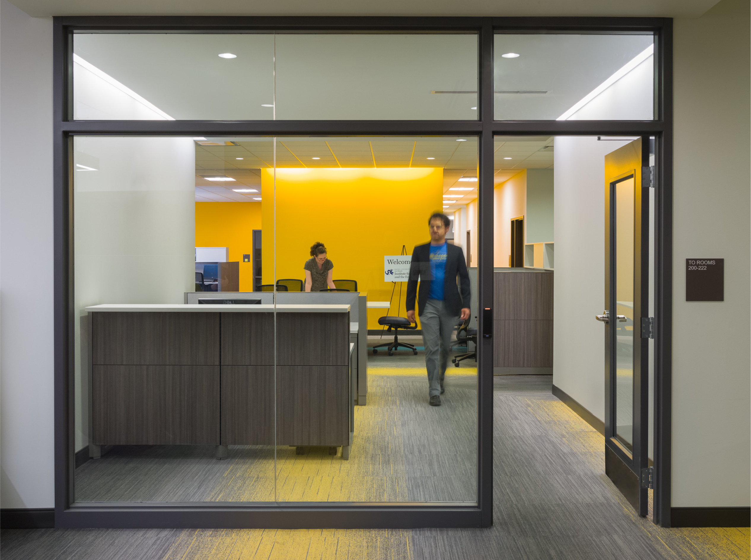 People are in the office and a man walking toward the door