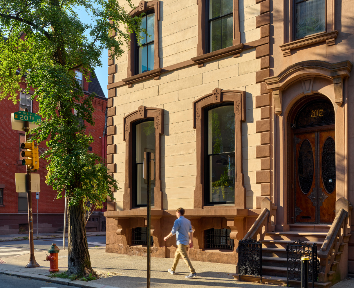 2000 Spruce Street exterior view with a person walking by