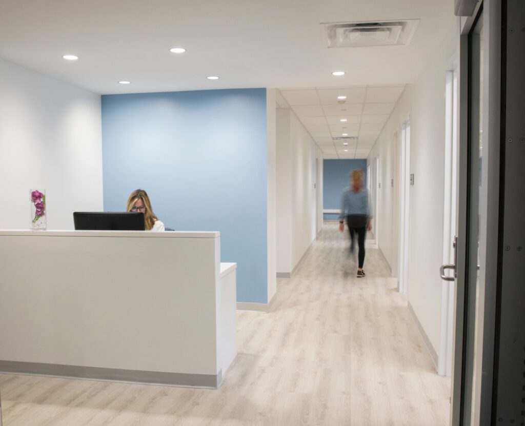 Penn State Athletic Center Hall with a woman working at a front desk and a person walking through the hall