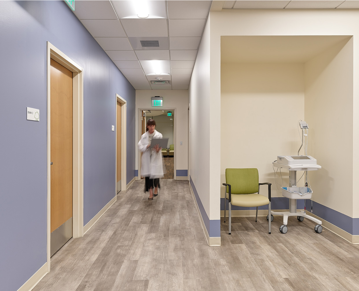 OSH hall with rooms and medical equipment. A doctor is walking through the hall