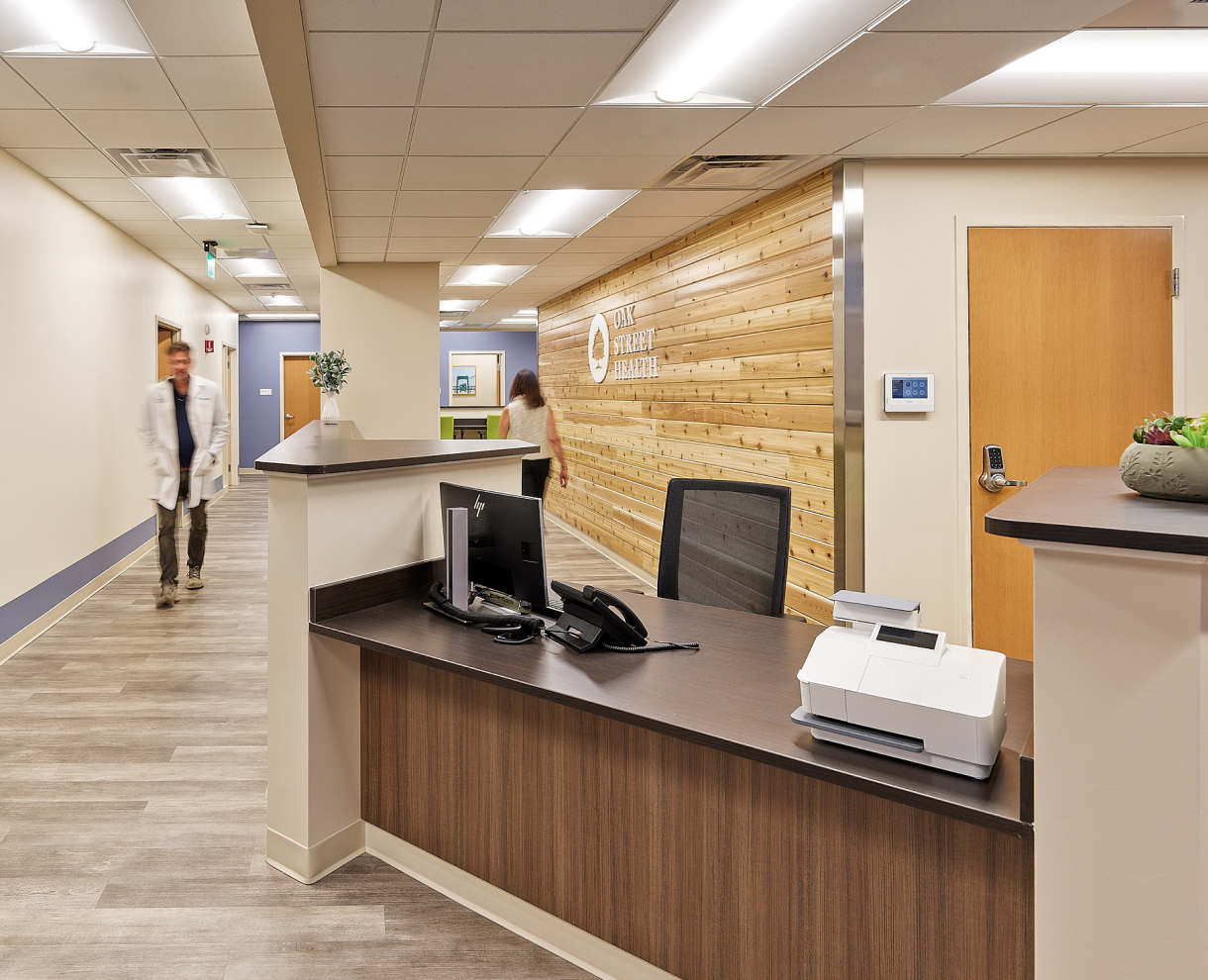 OSH reception with office devices and two people are walking around