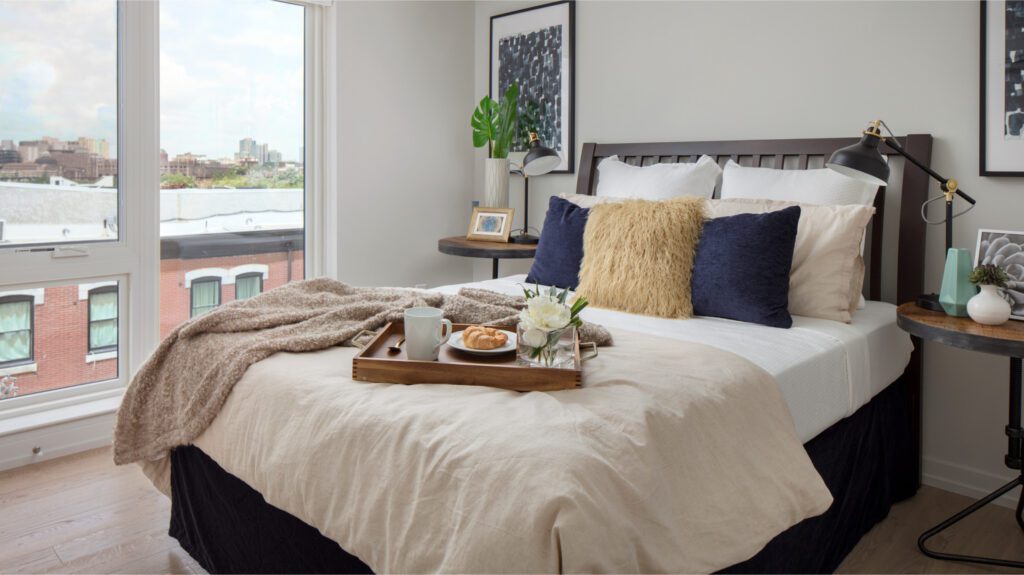 The Royer bedroom with breakfast on the bed and a big window