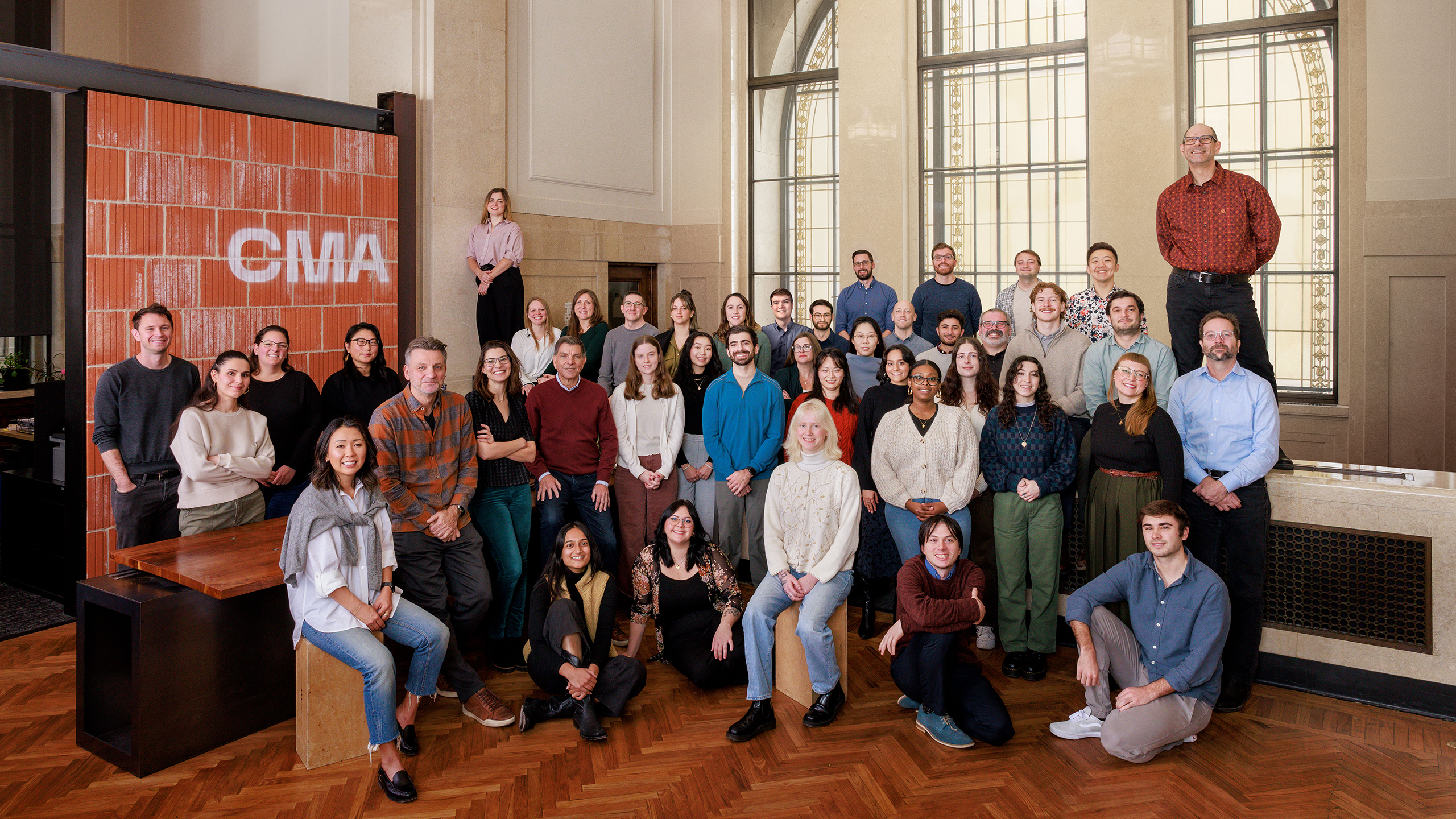 a group photo of the firm's employees in their office's reception area