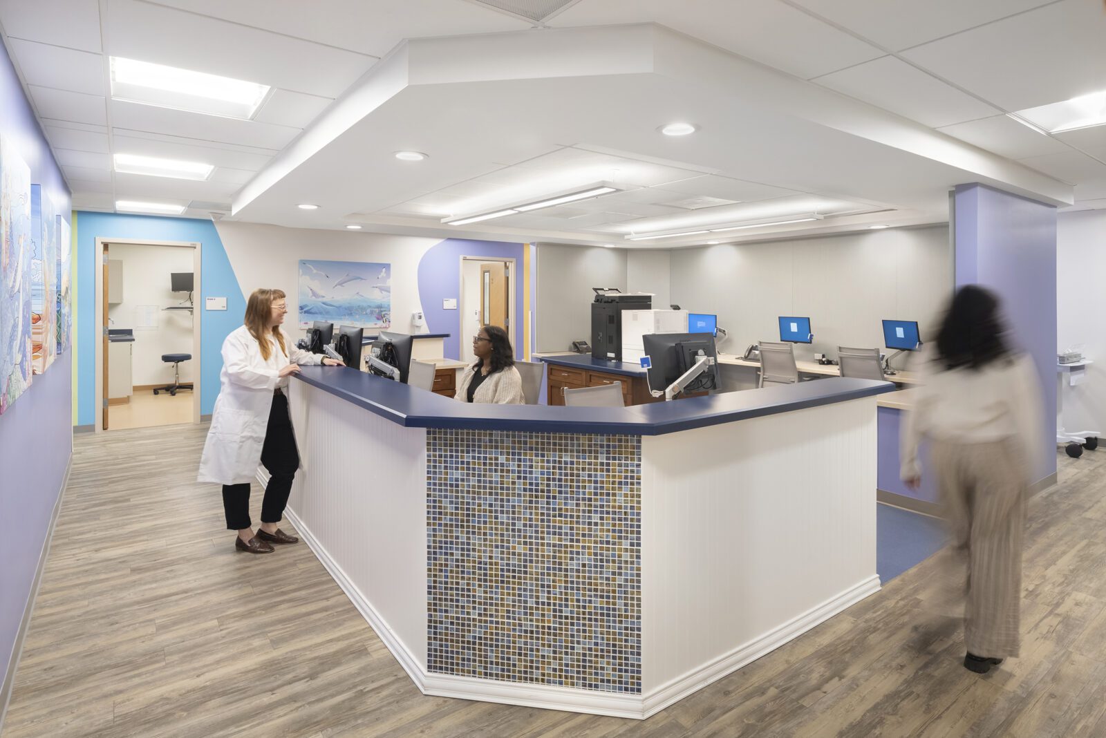 a nurse's station. the walls are painted blues, while a number of paintings of dolphins and other ocean animals are featured on the walls.